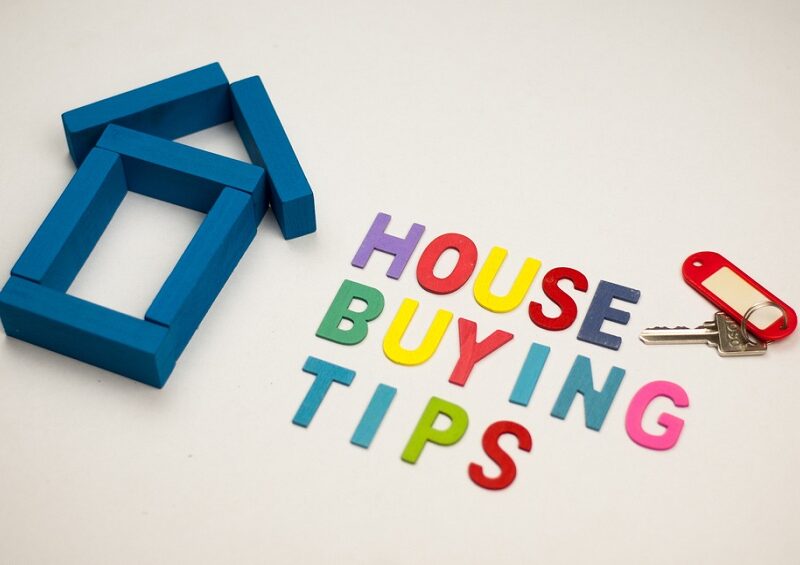 House model and wooden alphabet with text house buying tips